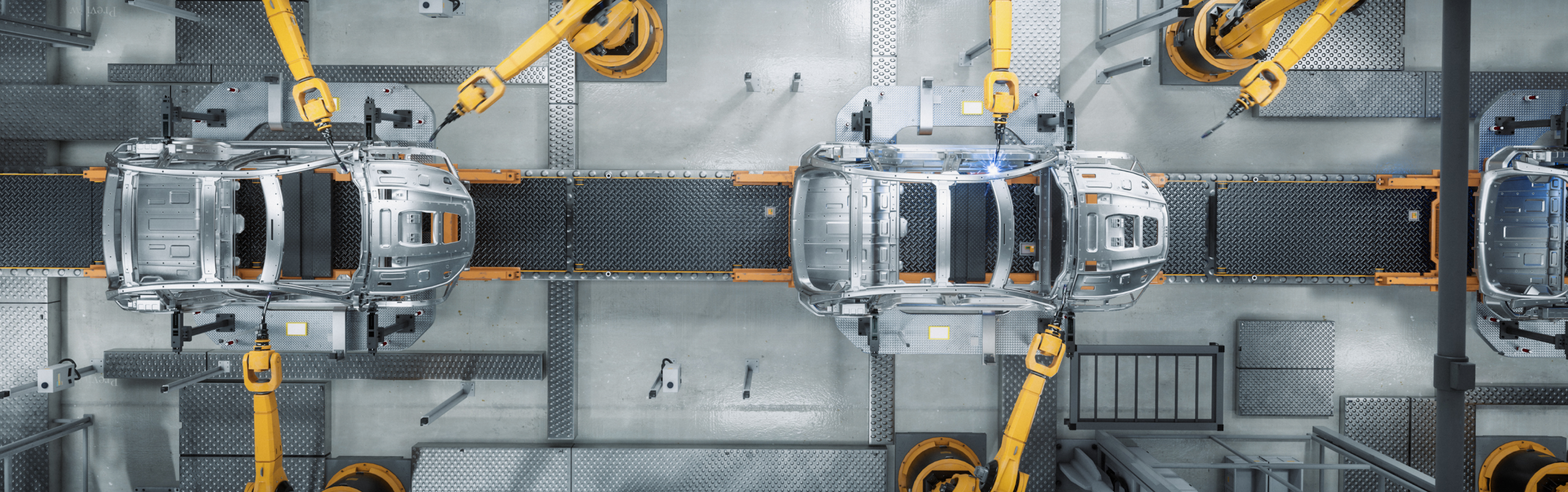  Robotic arms assembling a car on a conveyor belt.