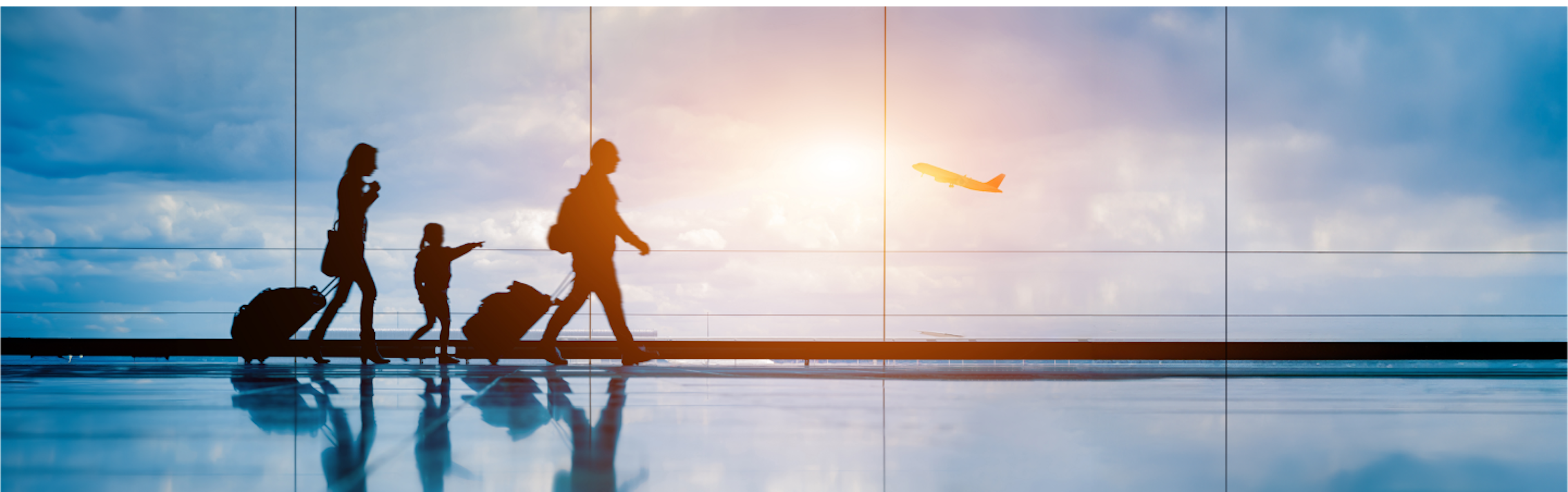 Silhouetted figures of a family with luggage walking in an airport terminal, with a plane taking off against a vibrant sunset in the background.