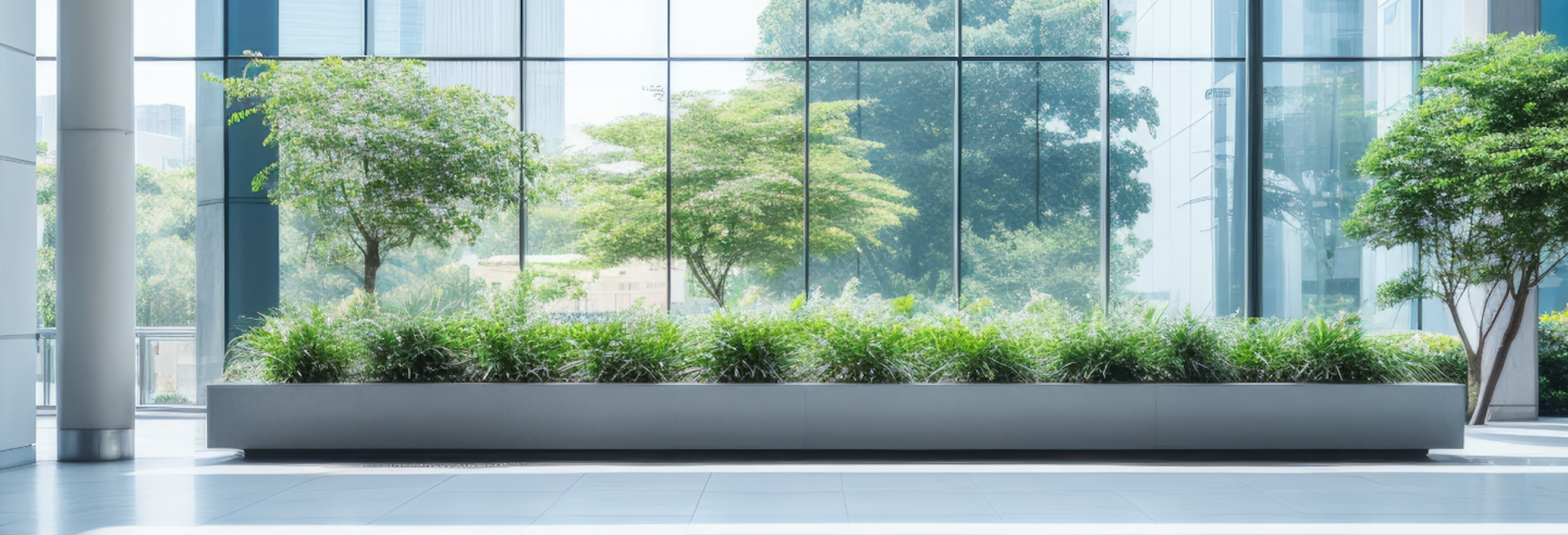 A row of houseplants in various pots getting sunlight from a large window.