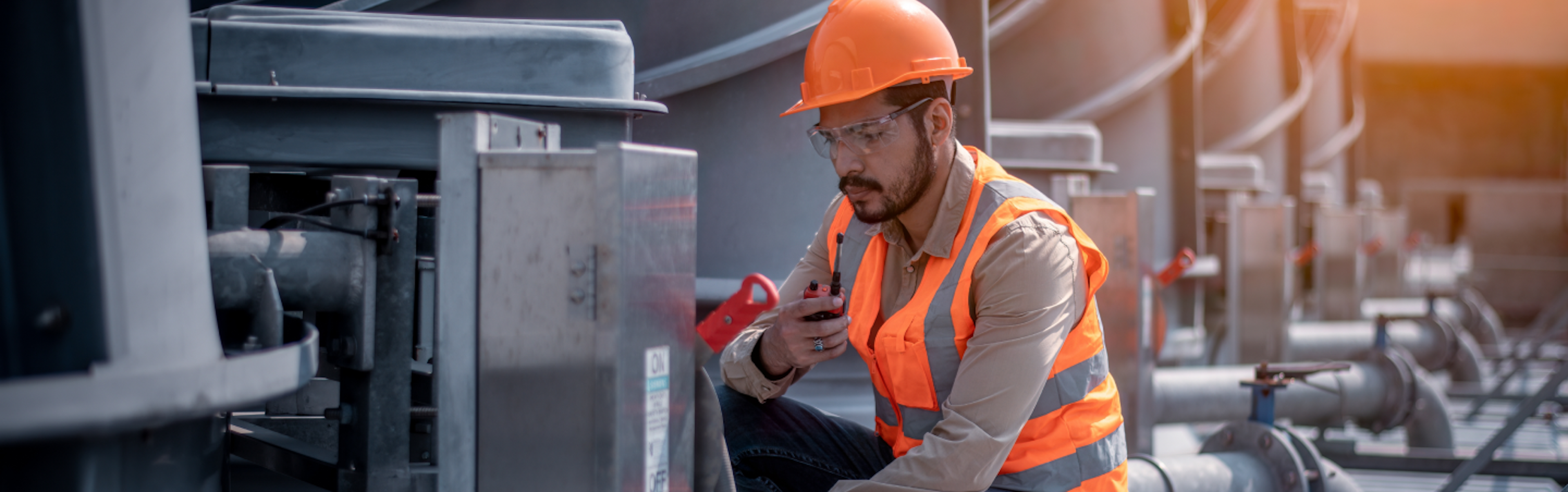 A person wearing safety gear working on heavy machenery